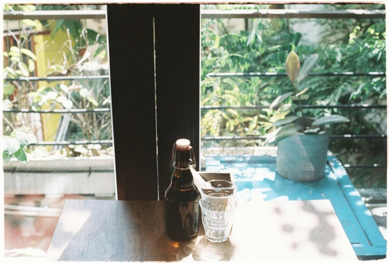 a glass bottle sitting on a table in front of a window