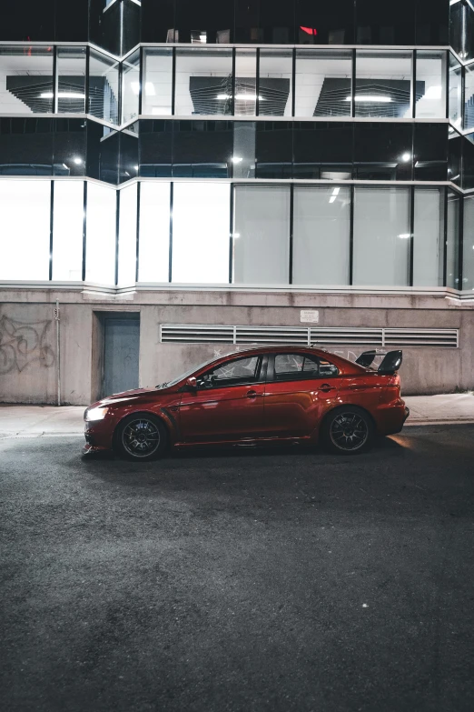 a red car in front of a glass building