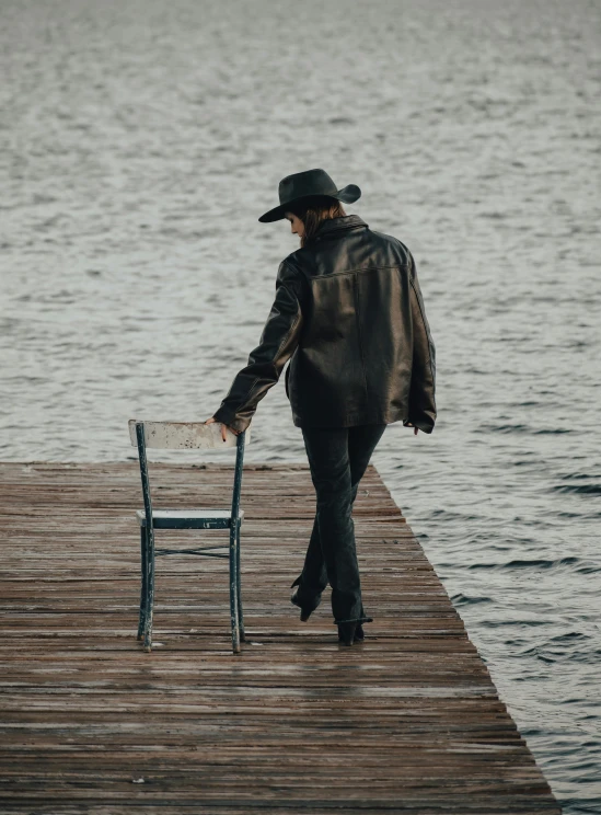 there is a man walking across a wooden pier