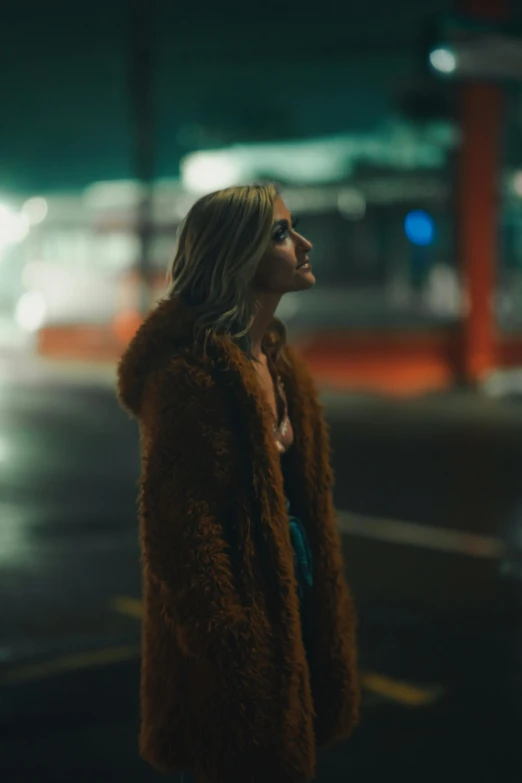 woman standing on street corner with fur coat over shoulder