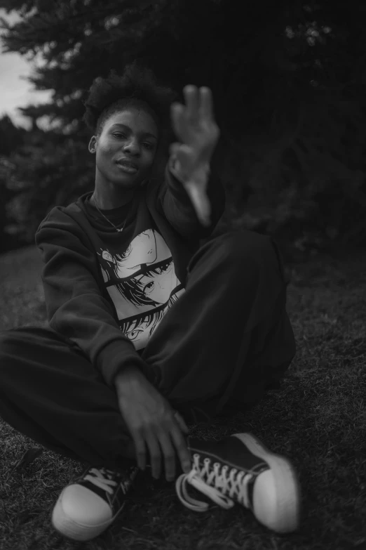 a black and white po of a person sitting on grass