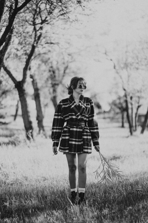 a woman wearing plaid clothes walking in a field