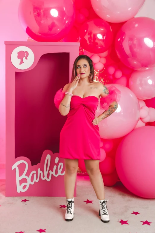 a woman is posing in front of a backdrop with balloons