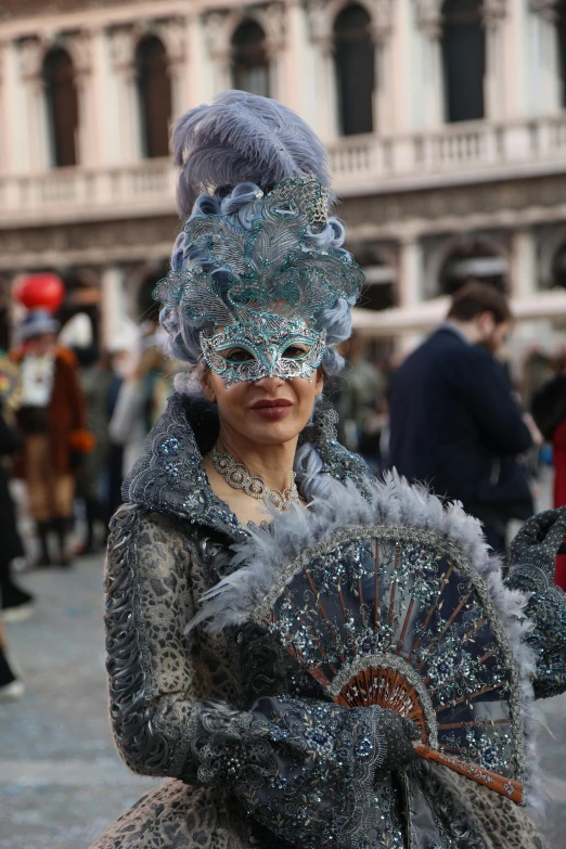 a woman in an ornate dress with feathers