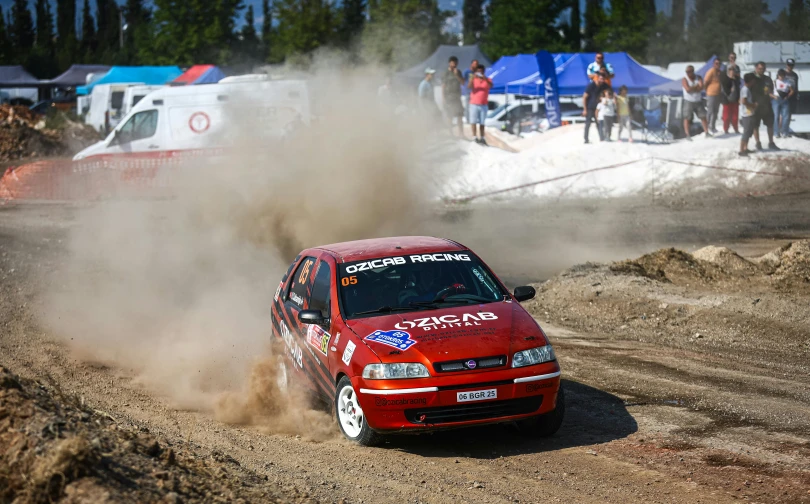 a person driving a red vehicle in the dirt