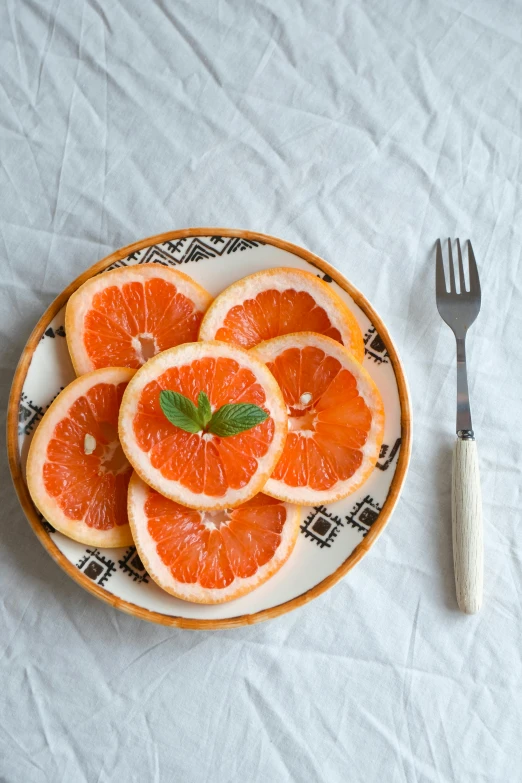 a white and black plate of orange slices on a table