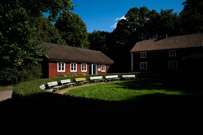 a red house next to a row of trees