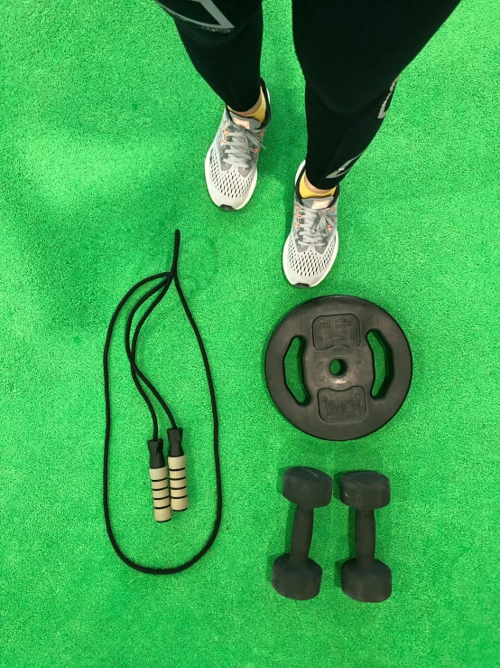 a person standing in front of some exercise equipment on a green carpet