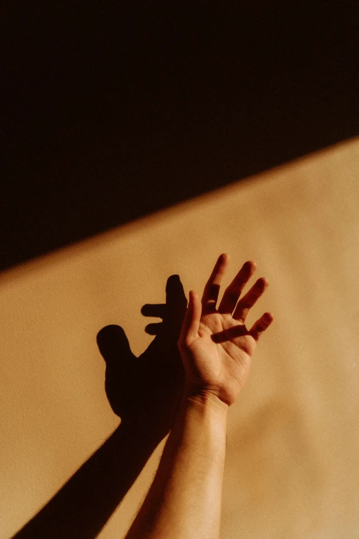 a persons hand reaching toward the light on top of a table