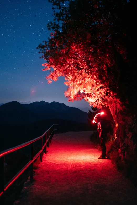 a dark and shadowy road surrounded by mountains and trees