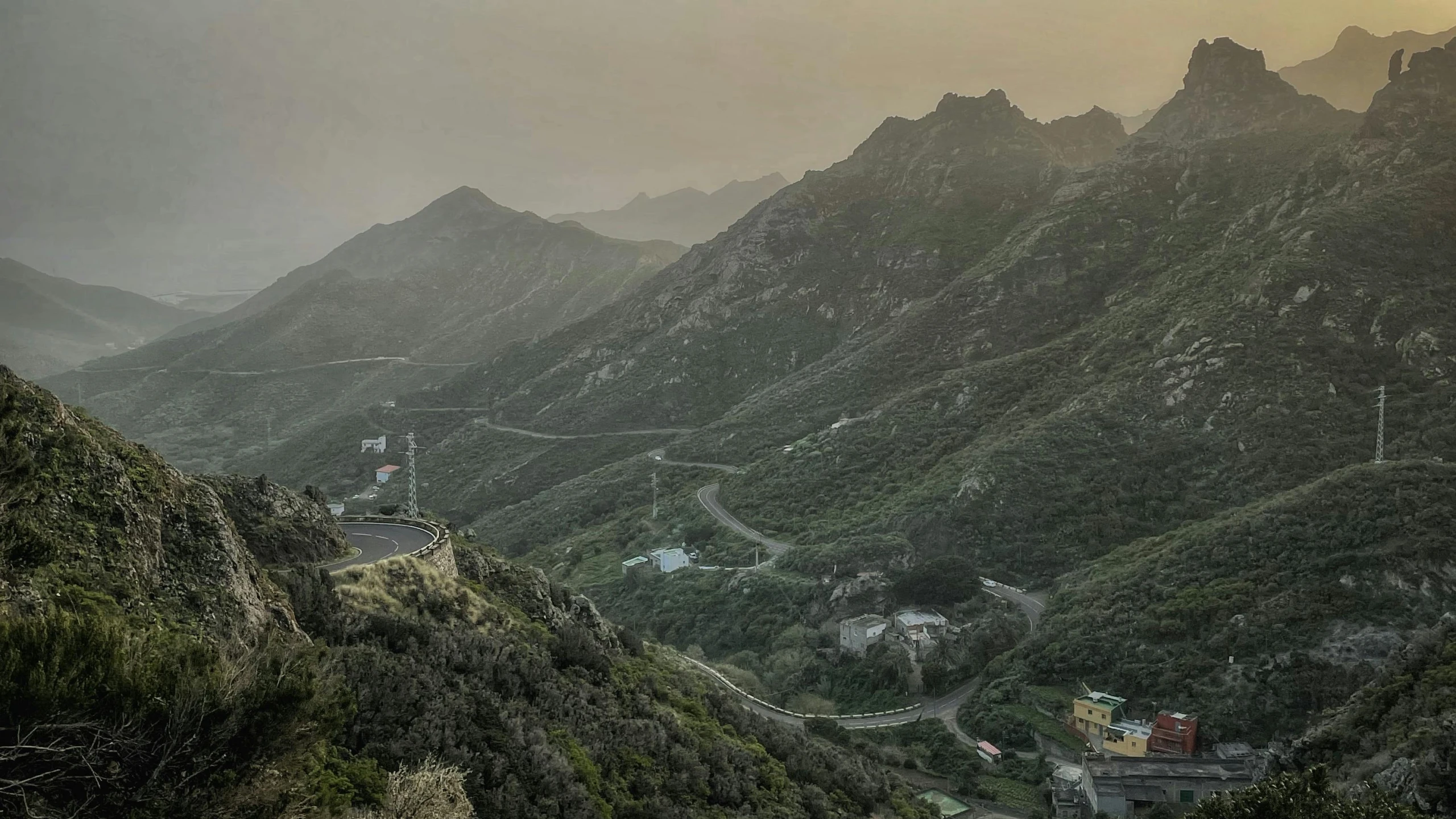 a valley in the mountains with trees on both sides