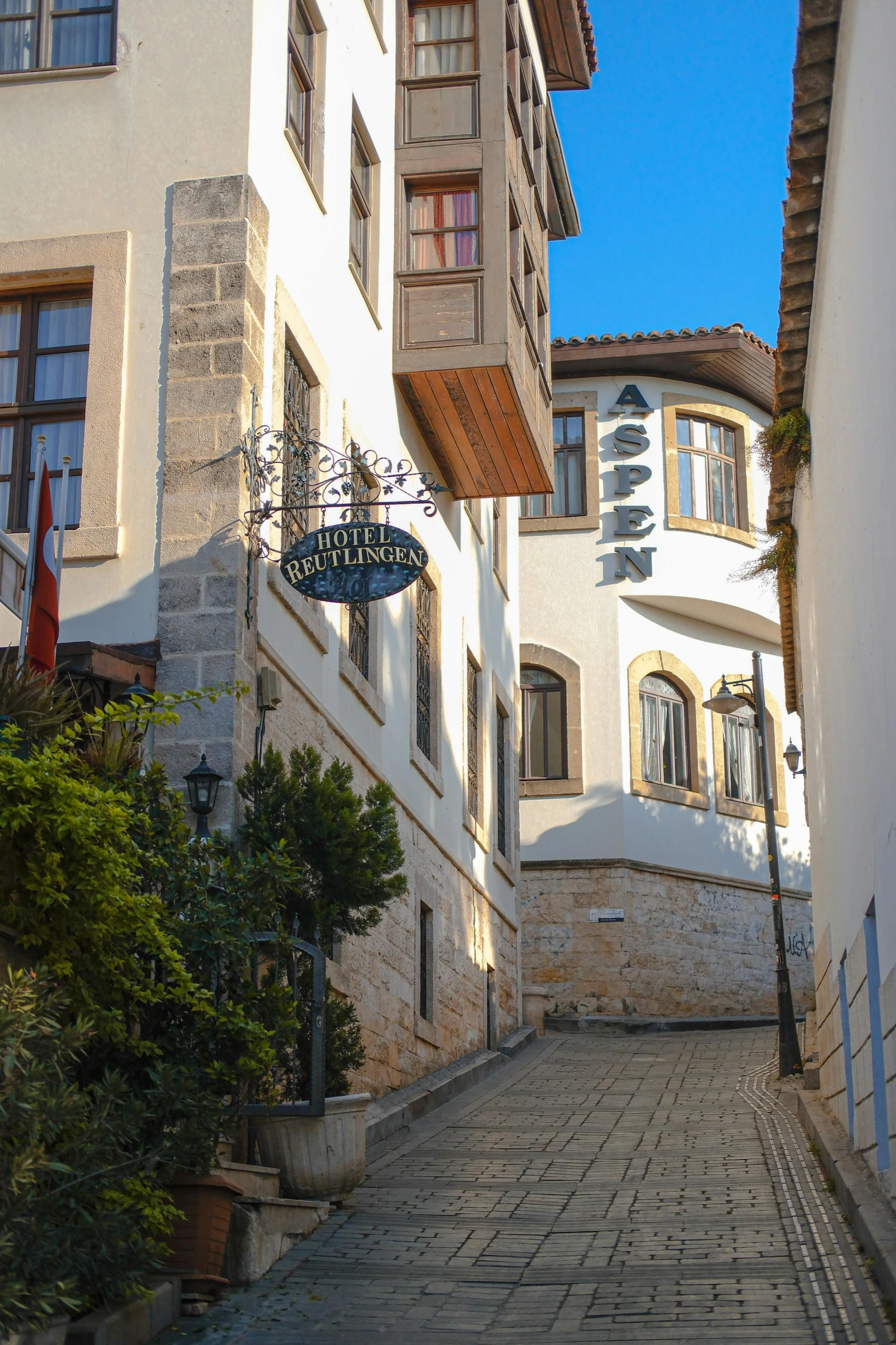 a long stone path with tall white buildings on both sides