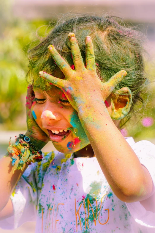 a child with colored hair and hands is playing