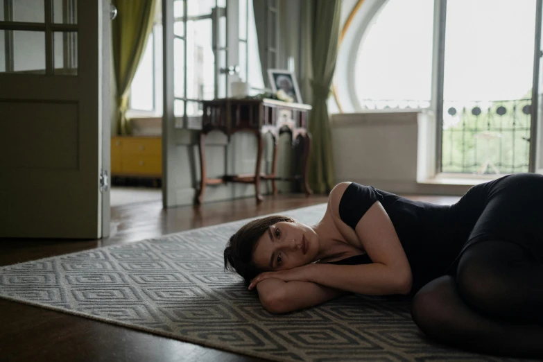 a woman in black outfit laying on floor next to a doorway