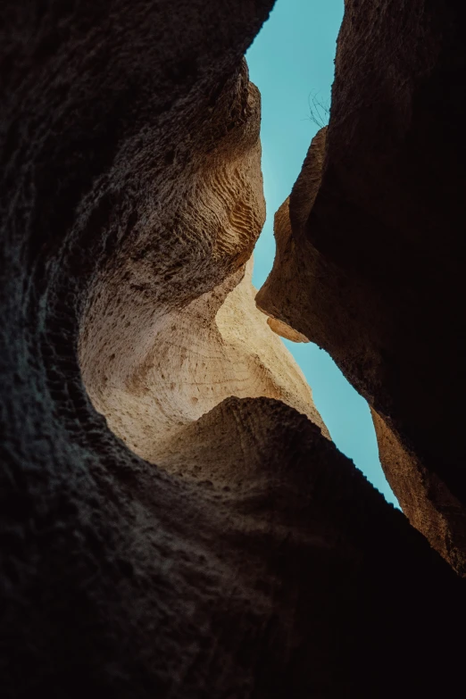 an unusual cliff face with one person coming from the side and the other one on top