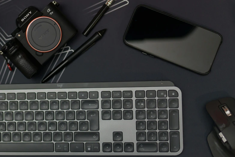 a camera sitting next to a keyboard on a desk