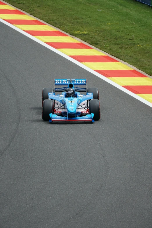 a blue racing car driving down a race track