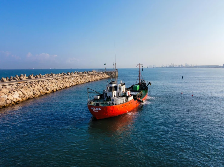 the small boat is tied to the dock by the cement