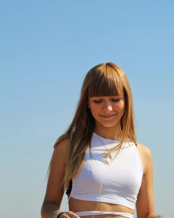 a young woman with blonde hair looking down at her cell phone