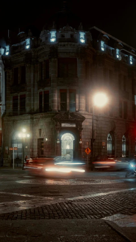 an old building lit up with lights on its corner