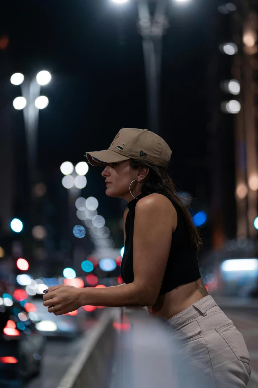 the woman is wearing a hat and looking out over the street