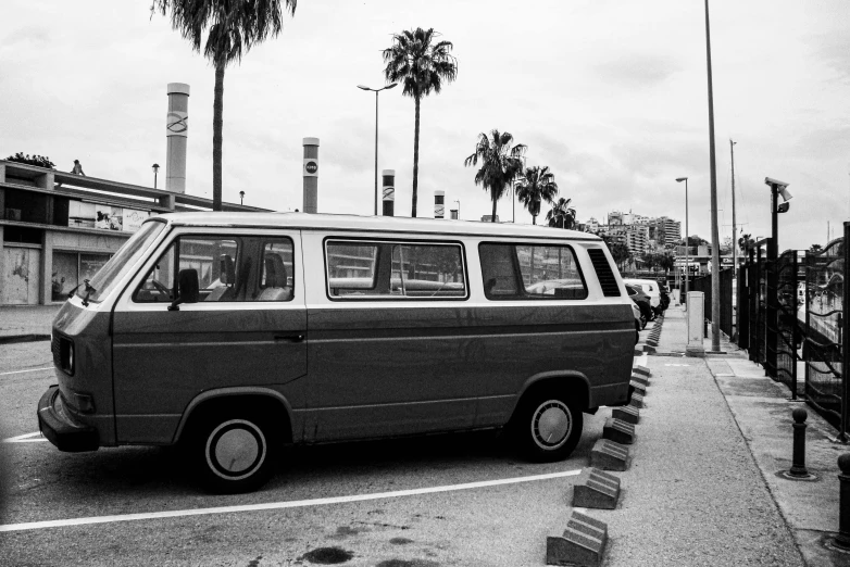 an old van parked by a curb in a parking lot