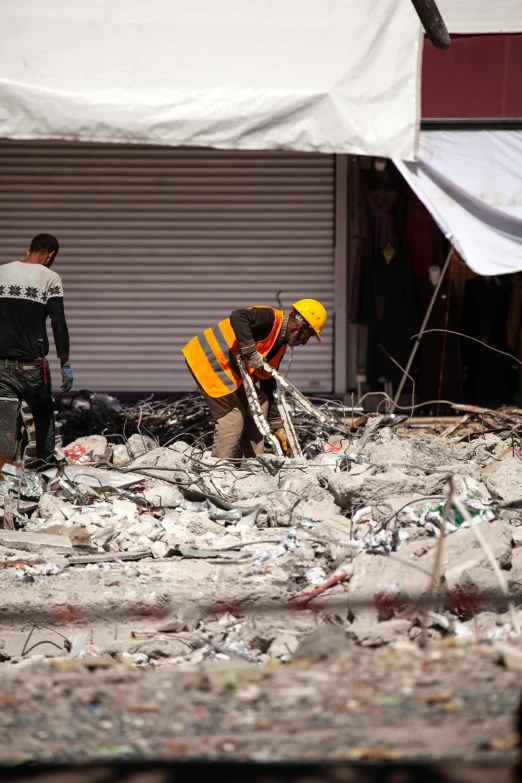 two men are standing in front of a pile of debris