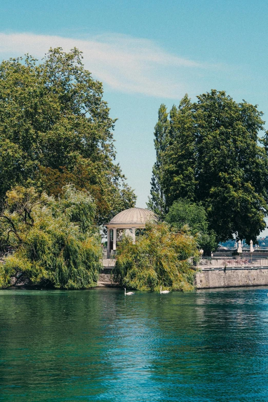 water is crystal blue and green with a gazebo and trees around it