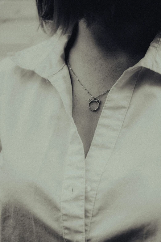 a woman is wearing a white shirt and has a necklace