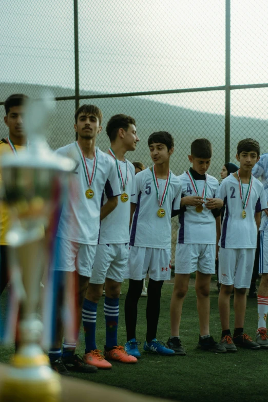 a group of children wearing soccer uniforms and medals