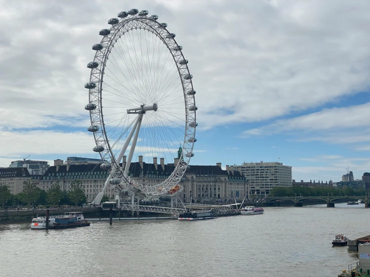 the london eye with boats and ships on the water