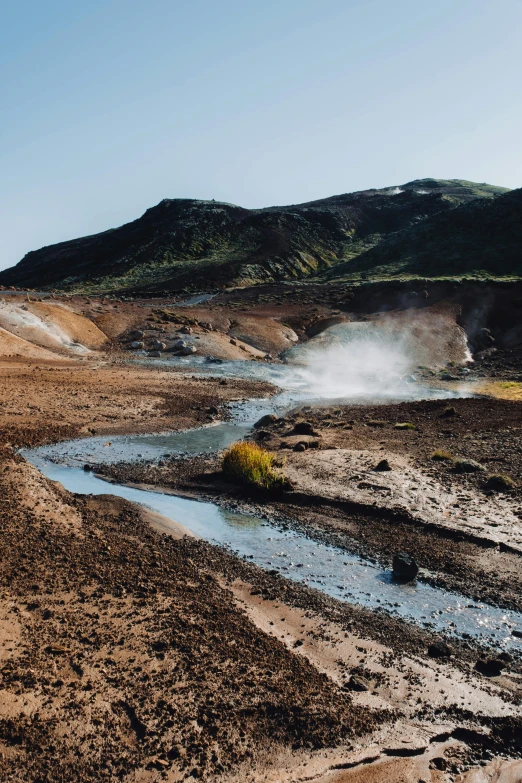 an image of the dirt field and mountains with water coming out