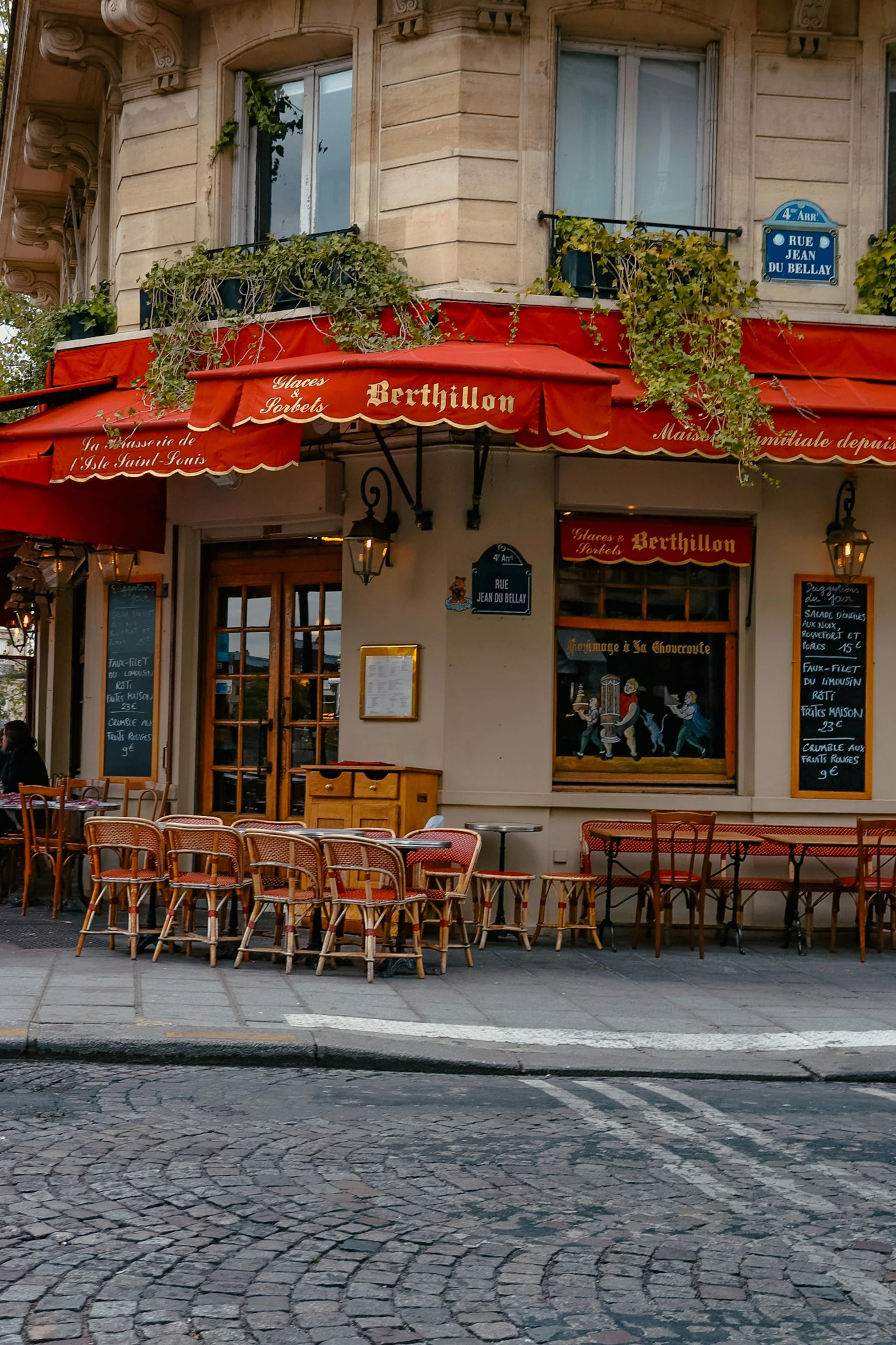 tables and chairs outside of a restaurant under an umbrella