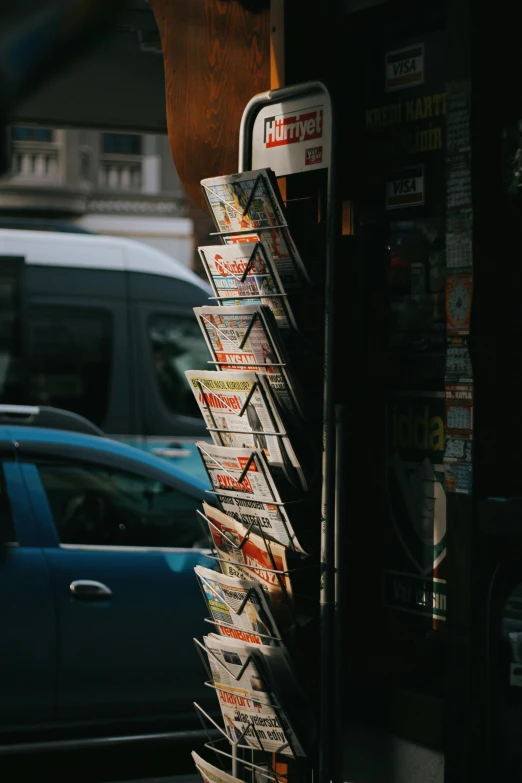 a newspaper dispenser sits in the foreground of a street