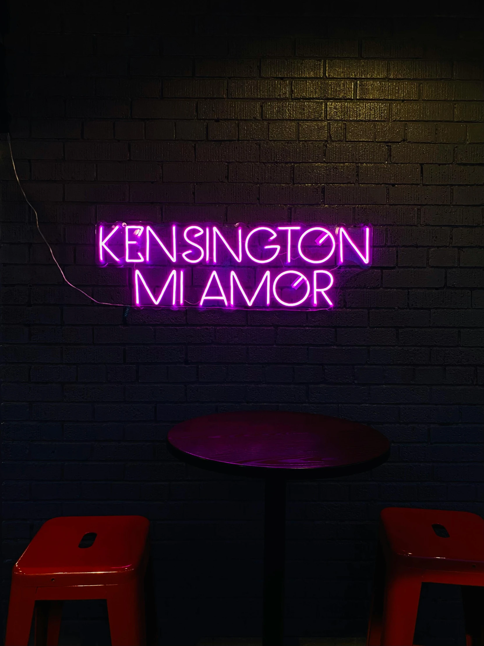 there is a neon sign lit up on a wall