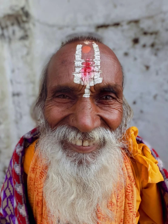 a man with white and orange headdress has long hair