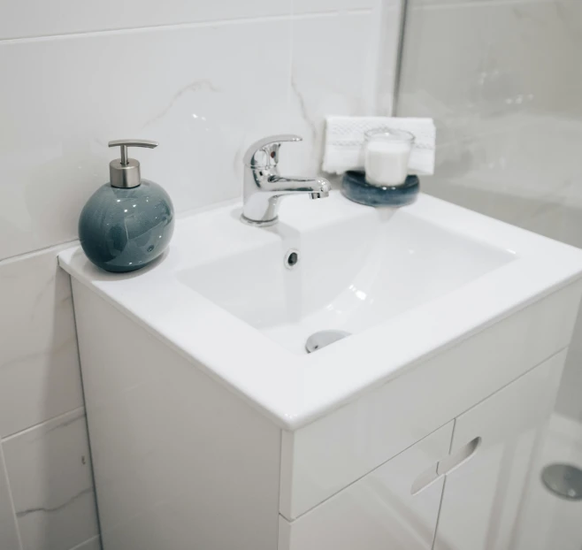 a bathroom sink with soap and a towel on the wall