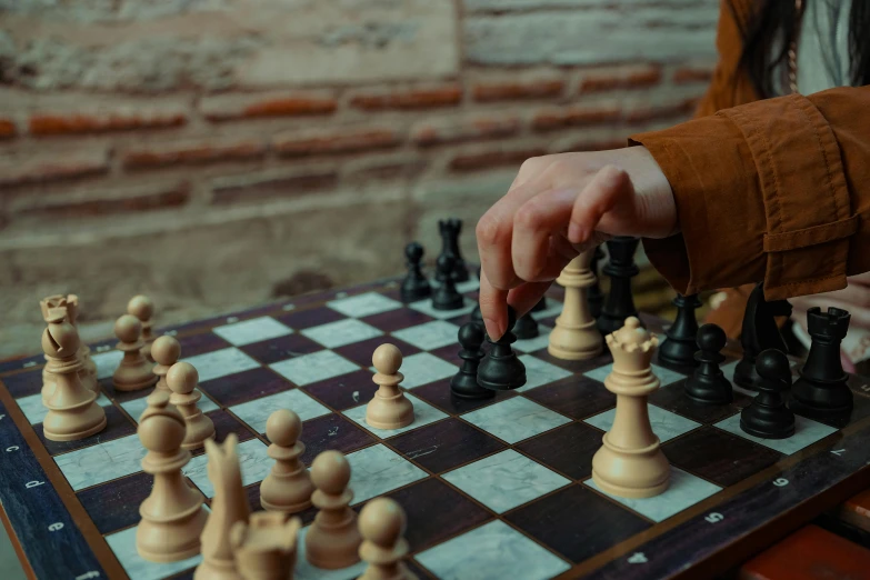 someone is playing a game of chess on a wooden board