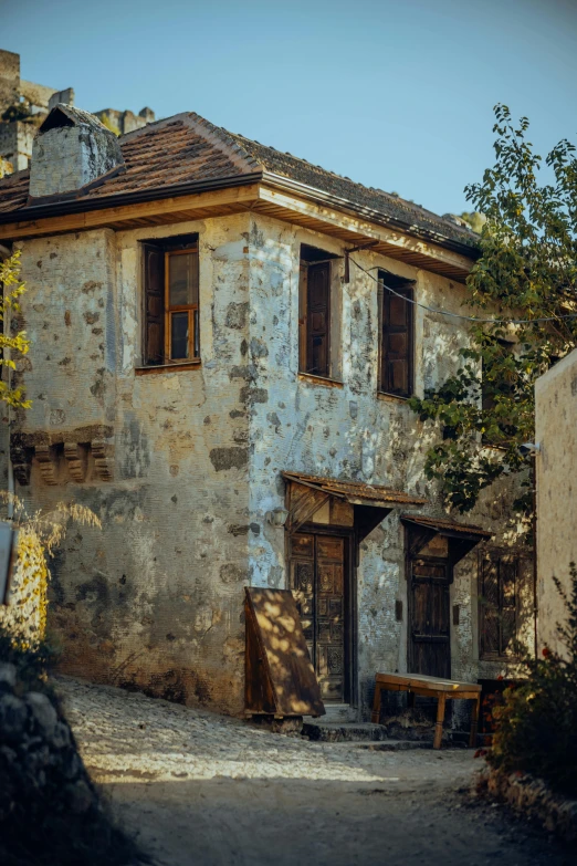 a run down house with a couple of small benches near the front