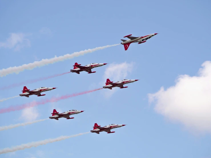 four planes flying in formation with smoke from behind them