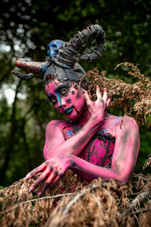 a lady with her face painted in colors, with long horns on