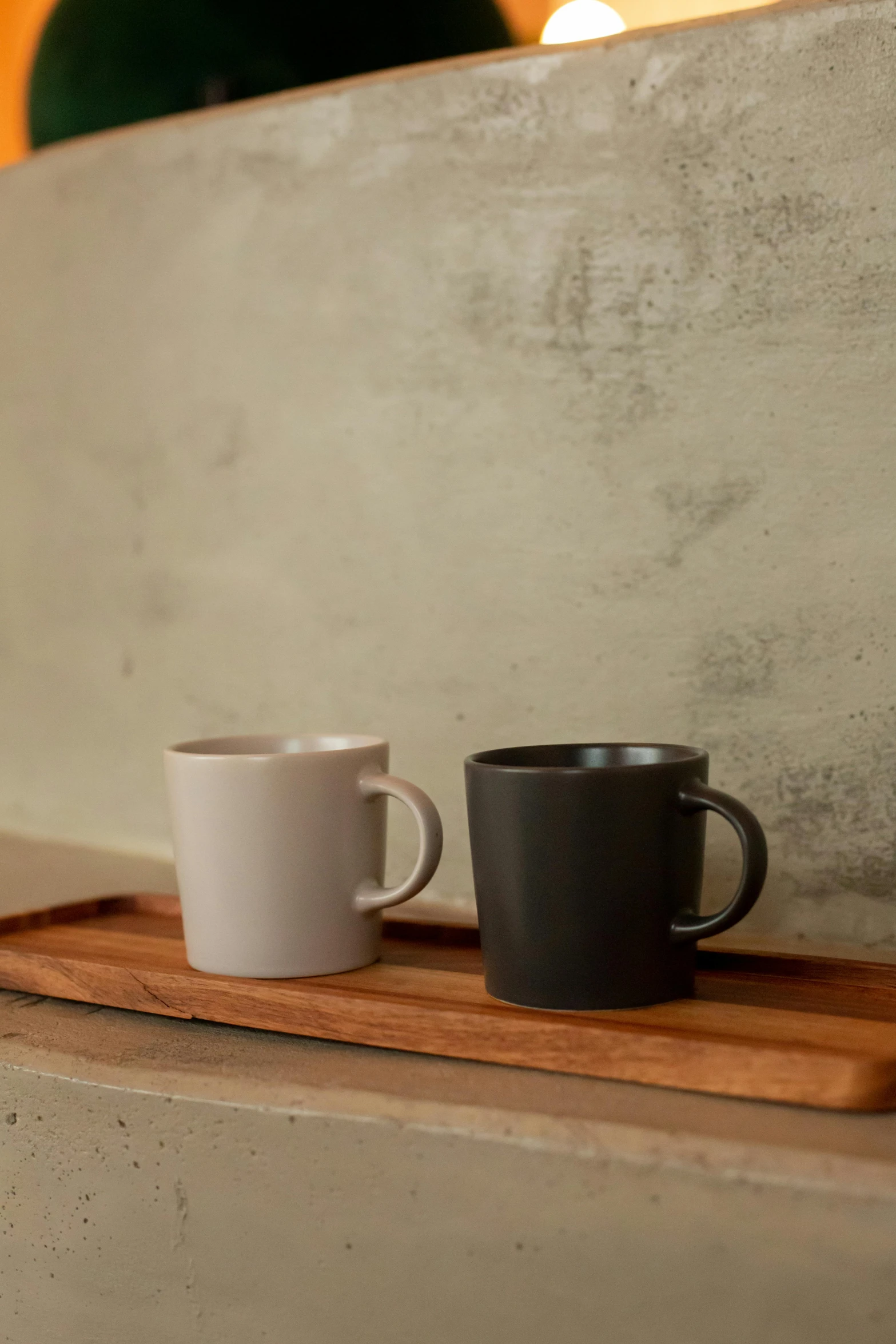 two cups are sitting on a wood plate