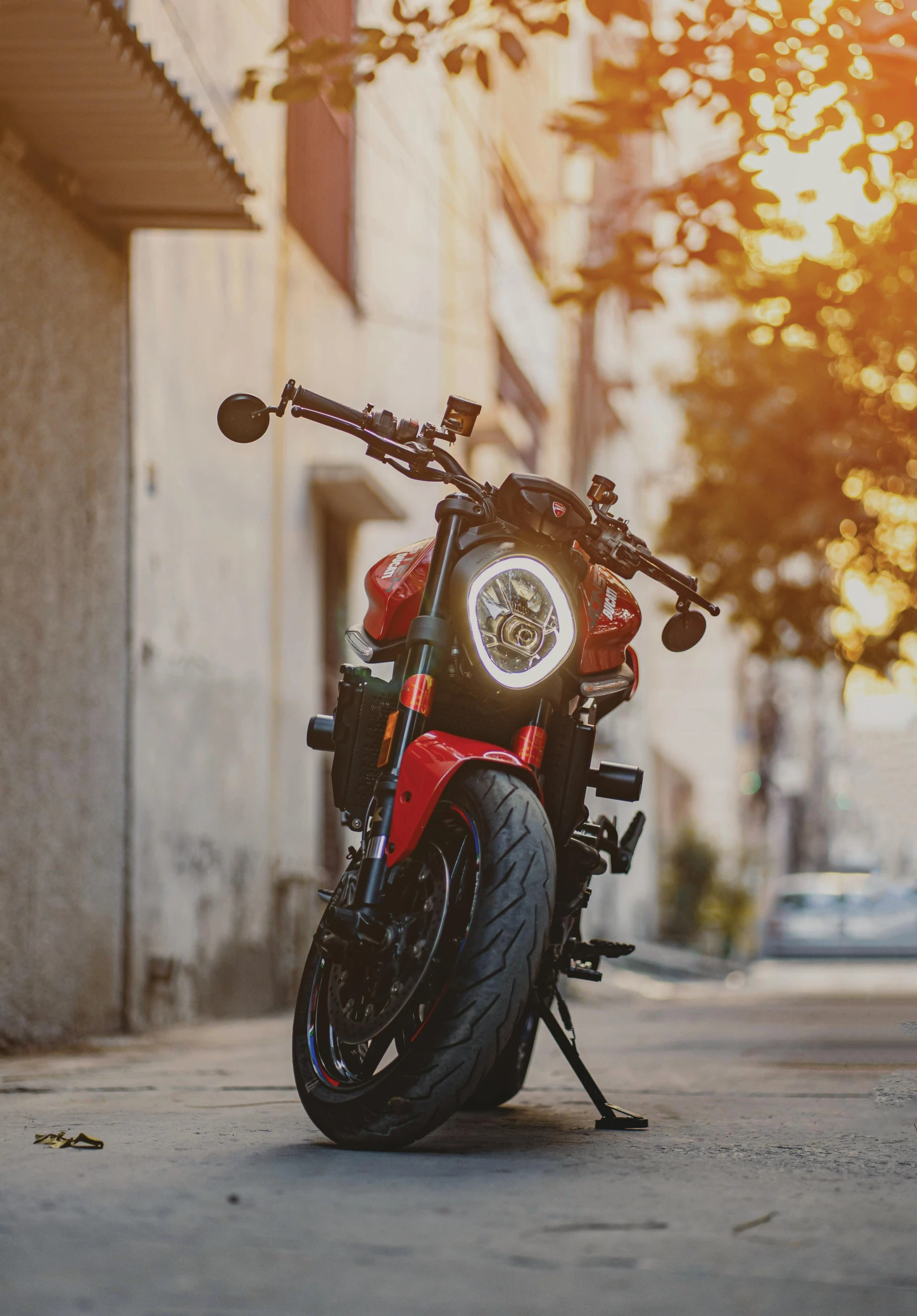 a red motorcycle parked in a sidewalk on the street