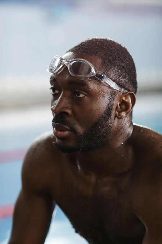 this man wearing goggles and a dirty swimming mask is looking off into the distance