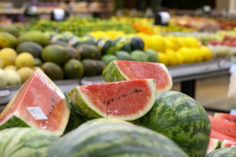 a lot of watermelons in the middle of a produce store