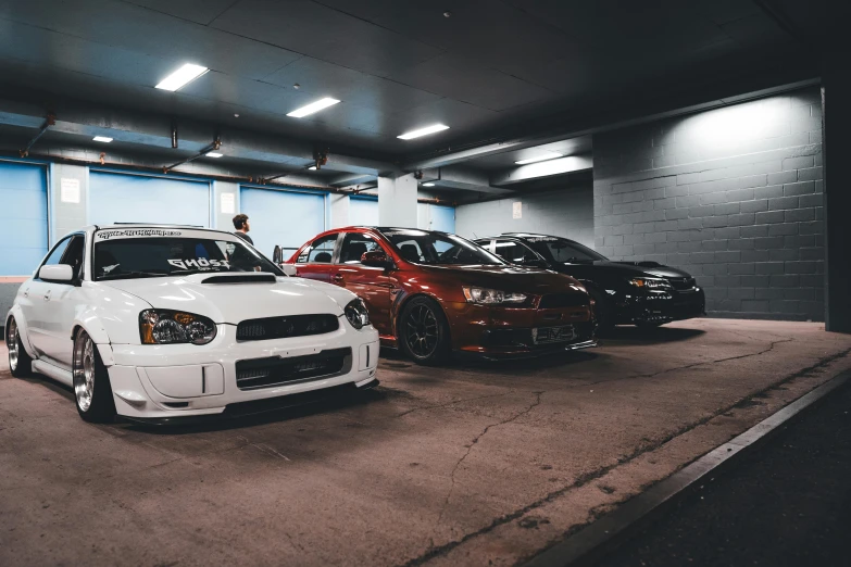 some cars are parked in an area with a concrete floor