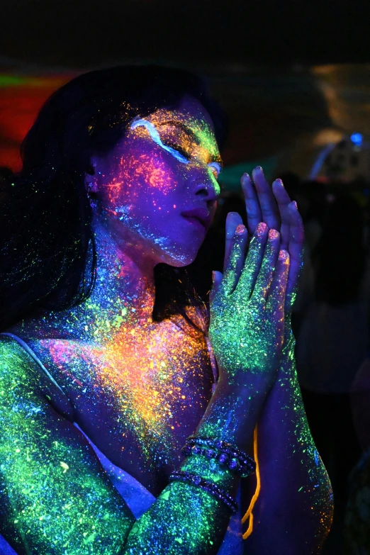 a woman wearing body paint poses with her hands to the side