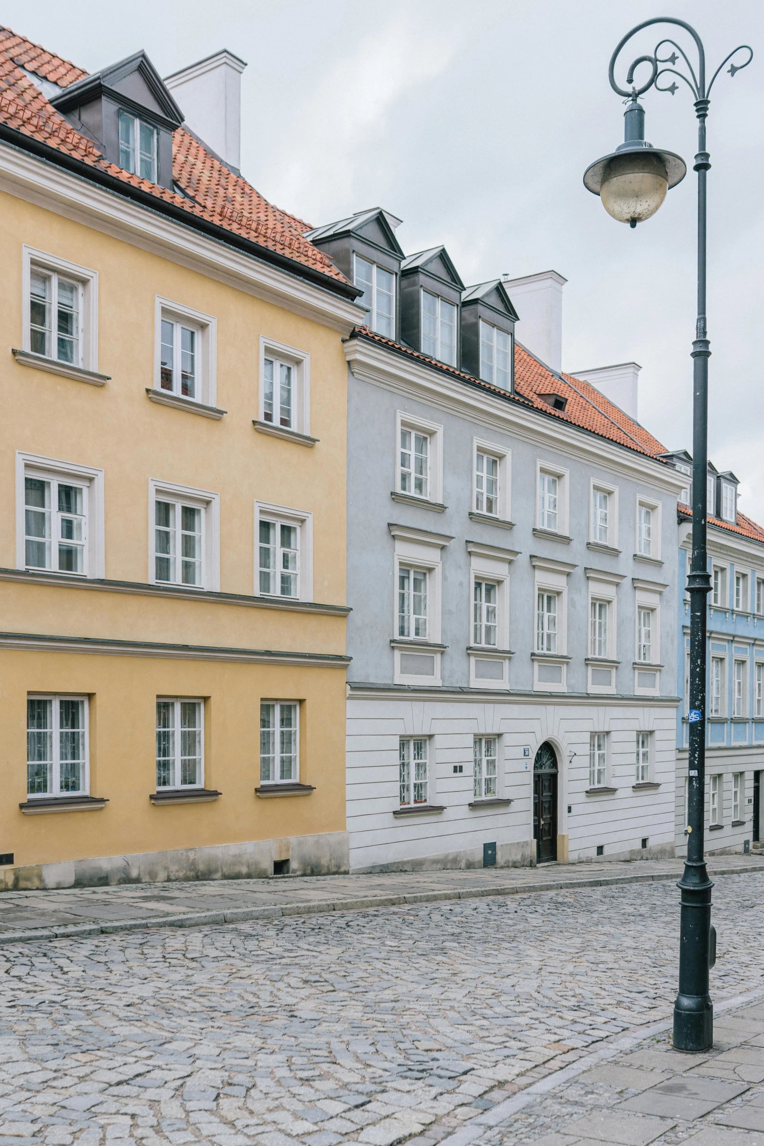 a stone street with several buildings and one lamp post