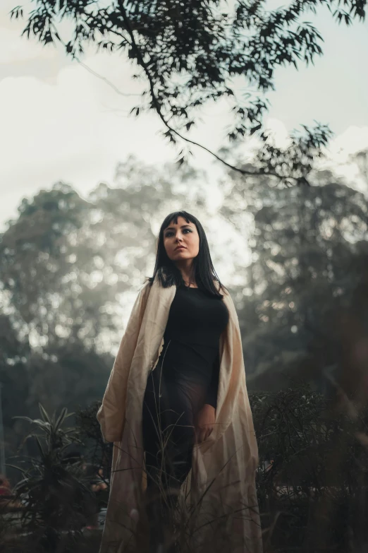 a young lady standing in the middle of tall grass