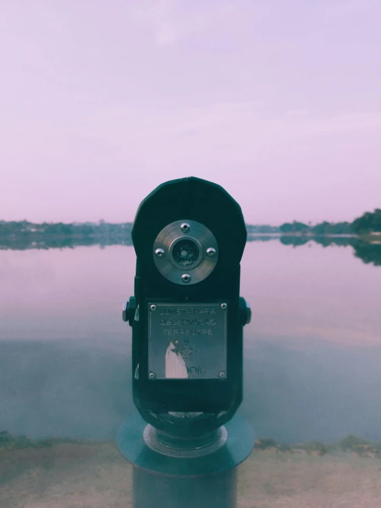 a close up of a metal object with water and sky in the background